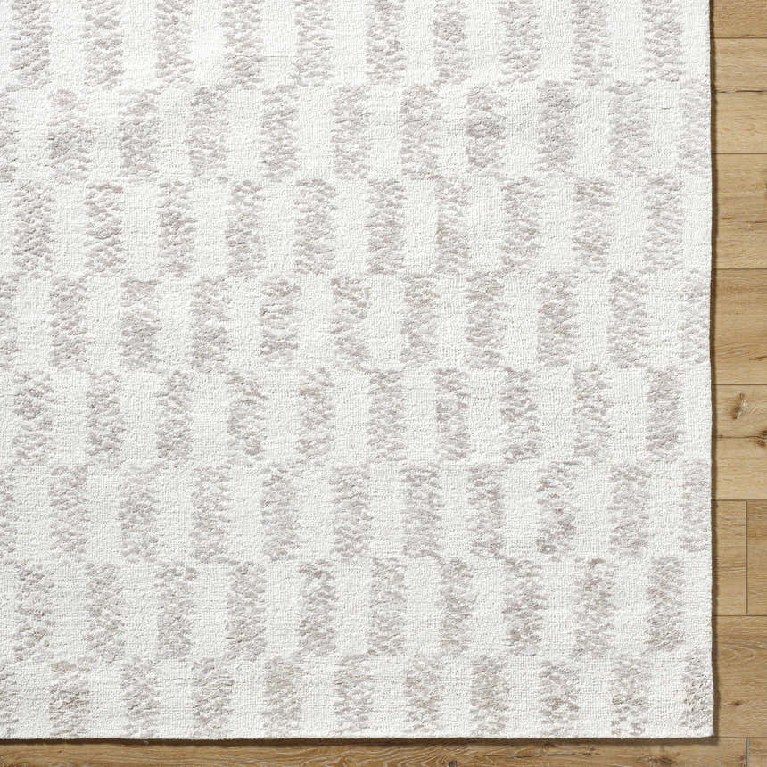 Close-up of Theda Area Rug. Hand-tufted 100% wool rug in ash, light silver, and off-white with a contemporary striped pattern. Corner