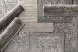 Close-up of the Watford Updated Traditional Tibetan Rug in charcoal, gray, ivory, and tan with a vintage floral pattern. Styleshot