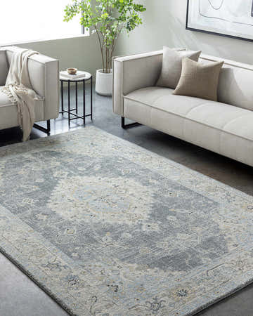 Living room scene with a gray sofa and the Tyche Tan Thick Luxe Area Rug. Roomscene-Rectangle