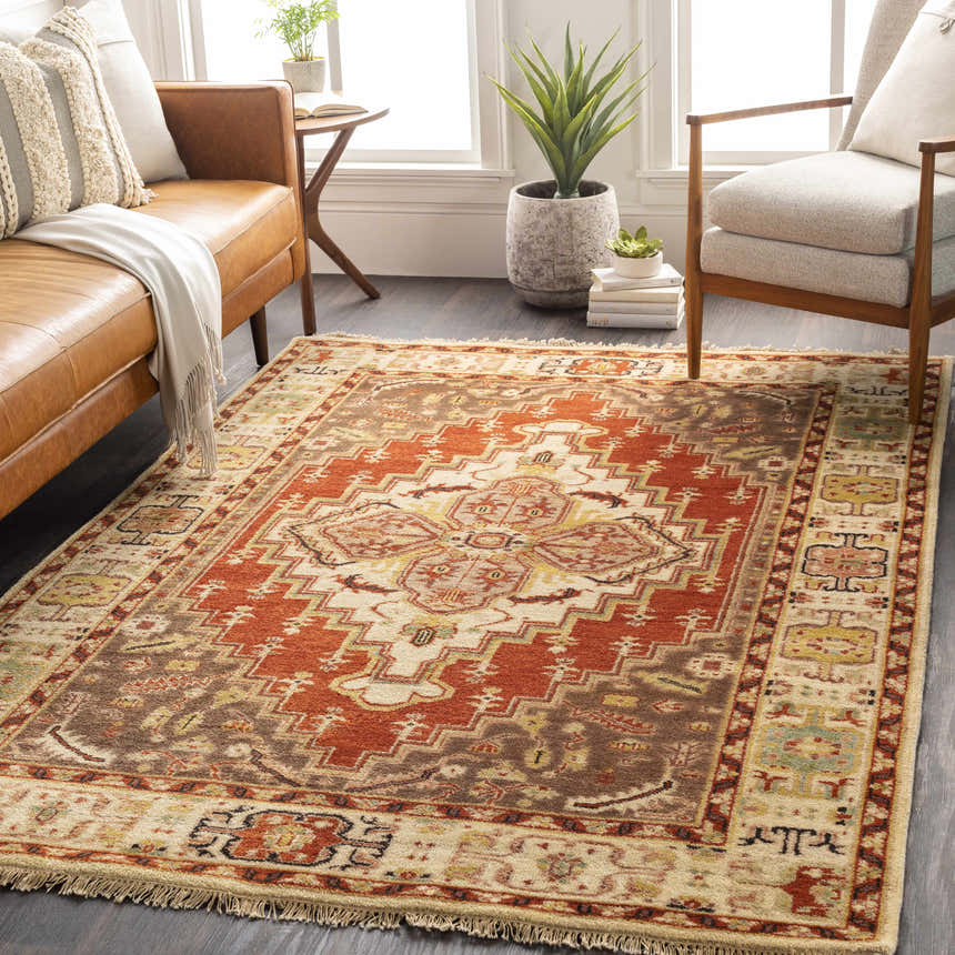 Living room scene with a rectangular Texico Area Rug in rust, brown, and beige with a traditional, hand-knotted design. Roomscene-Rectangle