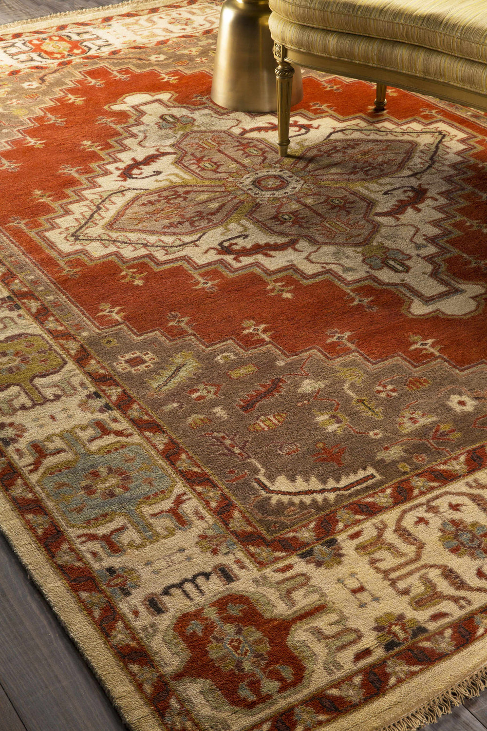 Close-up of the hand-knotted Texico Area Rug. Traditional farmhouse style in rust, beige, brown, and green tones. Styleshot