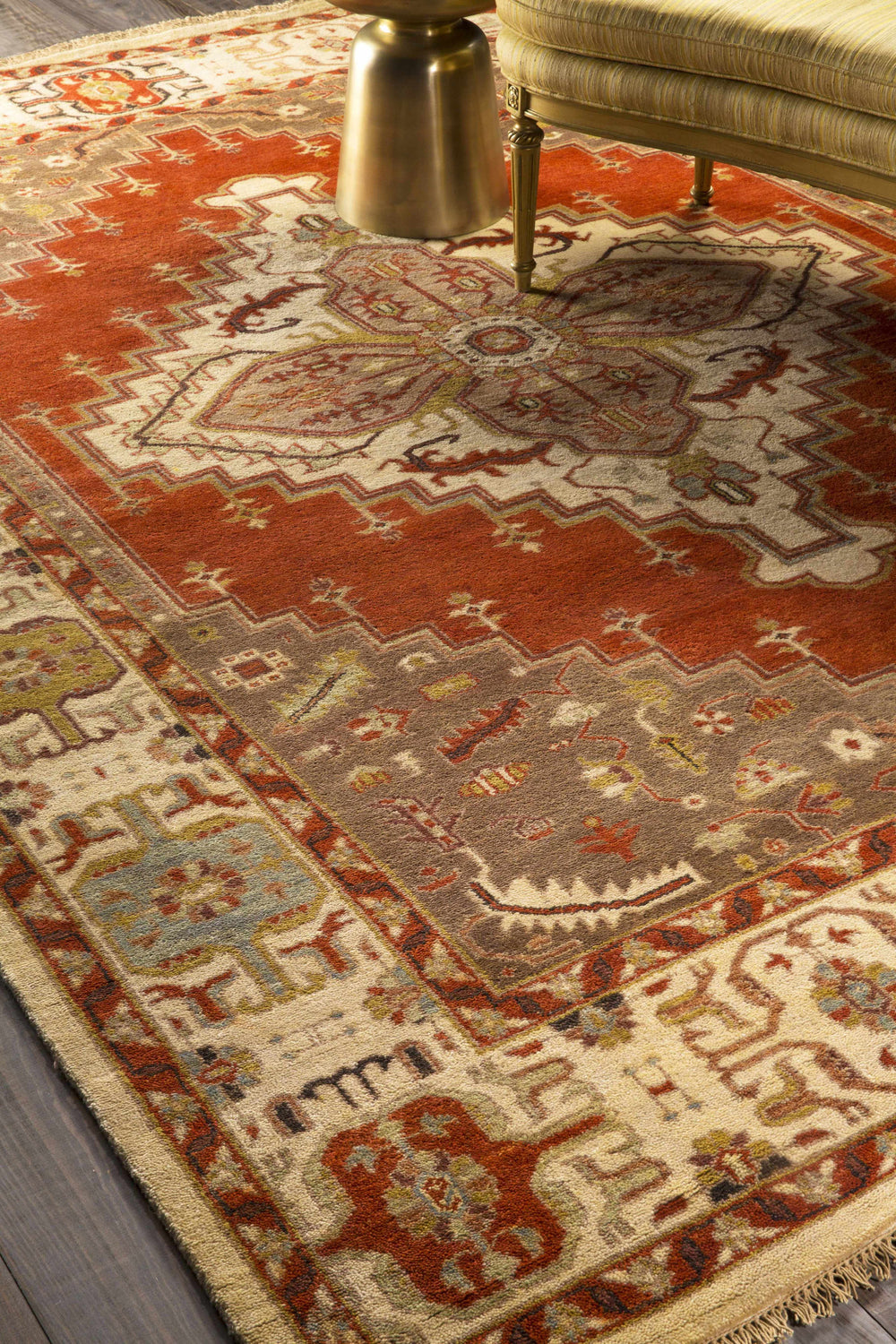 Close-up of the hand-knotted Texico Area Rug, a farmhouse style rug in rust, brown, and cream with traditional patterns. Styleshot