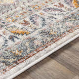 Close-up of the Thornley Area Rug showing its traditional oriental design with blue, orange, and pink hues. Texture