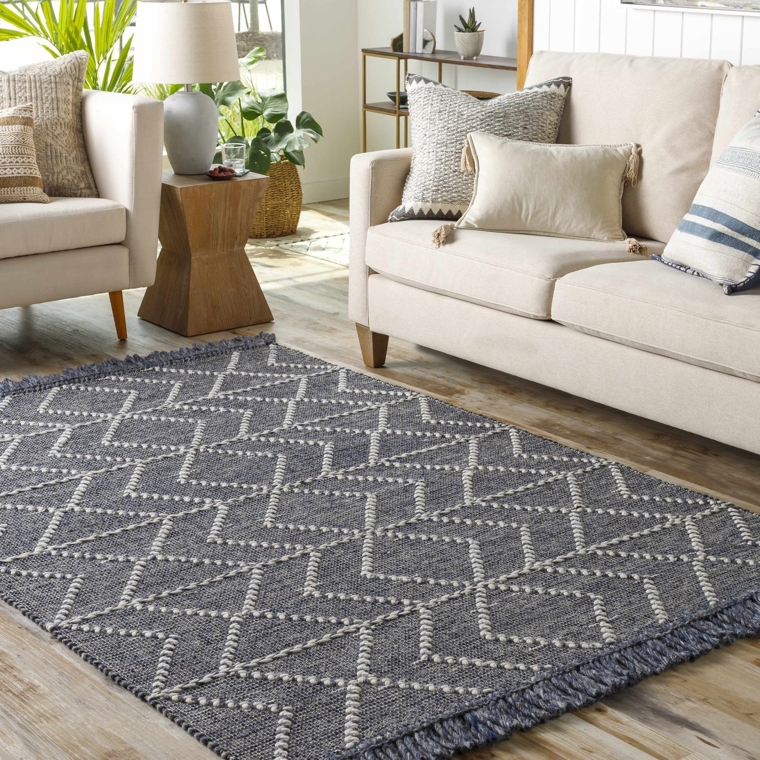 Living room with a charcoal and cream Tidman Area Rug, beige sofa, and natural light. Roomscene-Rectangle