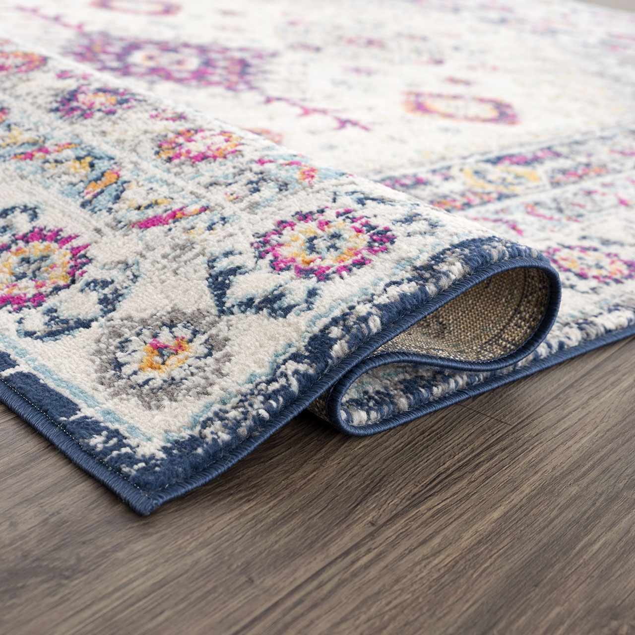 Close-up of Tigrim Beige 2306 Area Rug showing the bohemian floral pattern, ivory base, and navy border. Fold