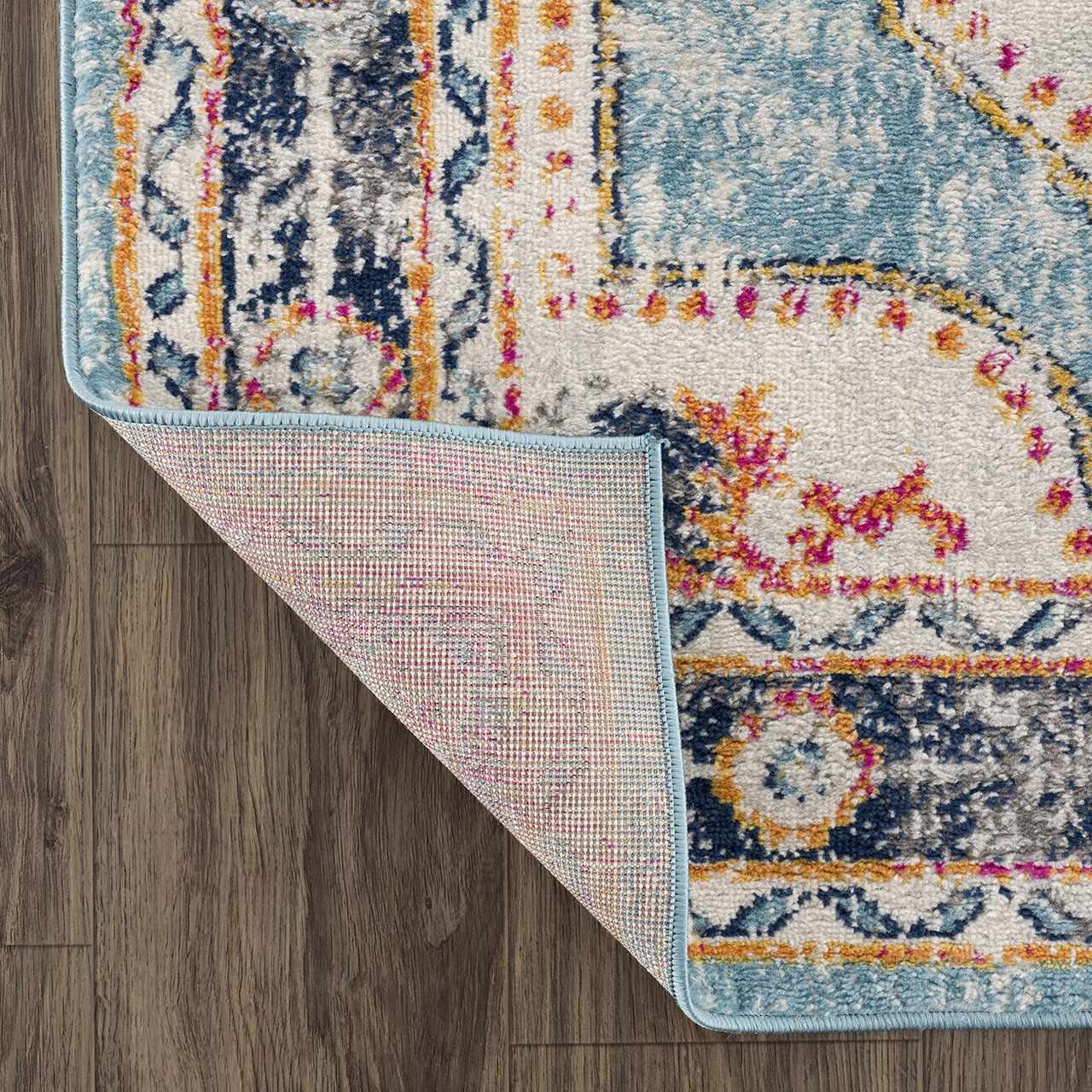 Close-up of Tigried Turquoise 2308 Area Rug showing blue, ivory, and orange bohemian pattern and rug backing. Fold
