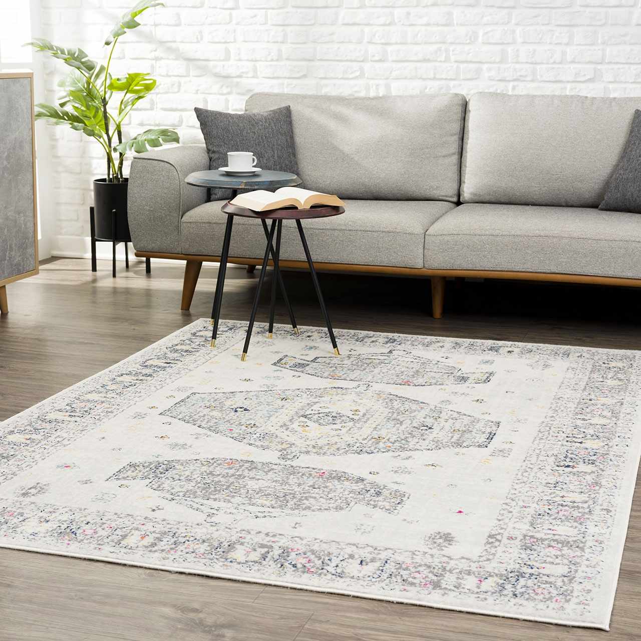 Living room scene with gray sofa and Tigried Ivory 2309 Area Rug. The rug has ivory, blue, gray, pink, and yellow tones. Roomscene-Rectangle