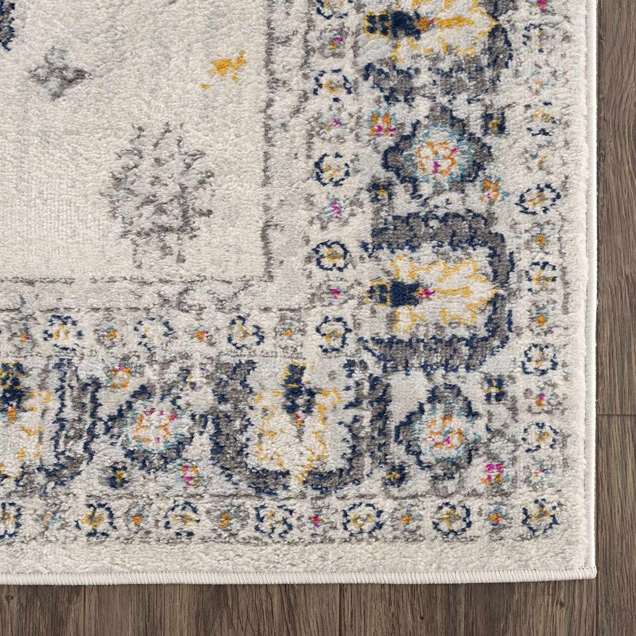 Close-up of the Tigried Ivory 2309 area rug showing its ivory, blue, gray, pink, and yellow bohemian pattern. Swatch