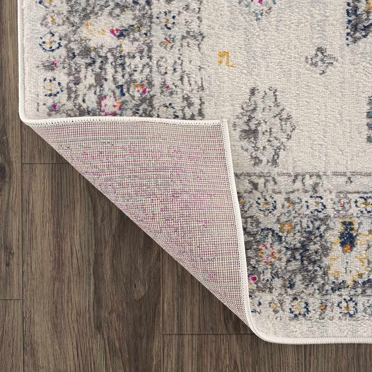 Close-up of the Tigried Ivory 2309 Area Rug showing the ivory, gray, blue, pink, and yellow pattern and rug backing. Fold