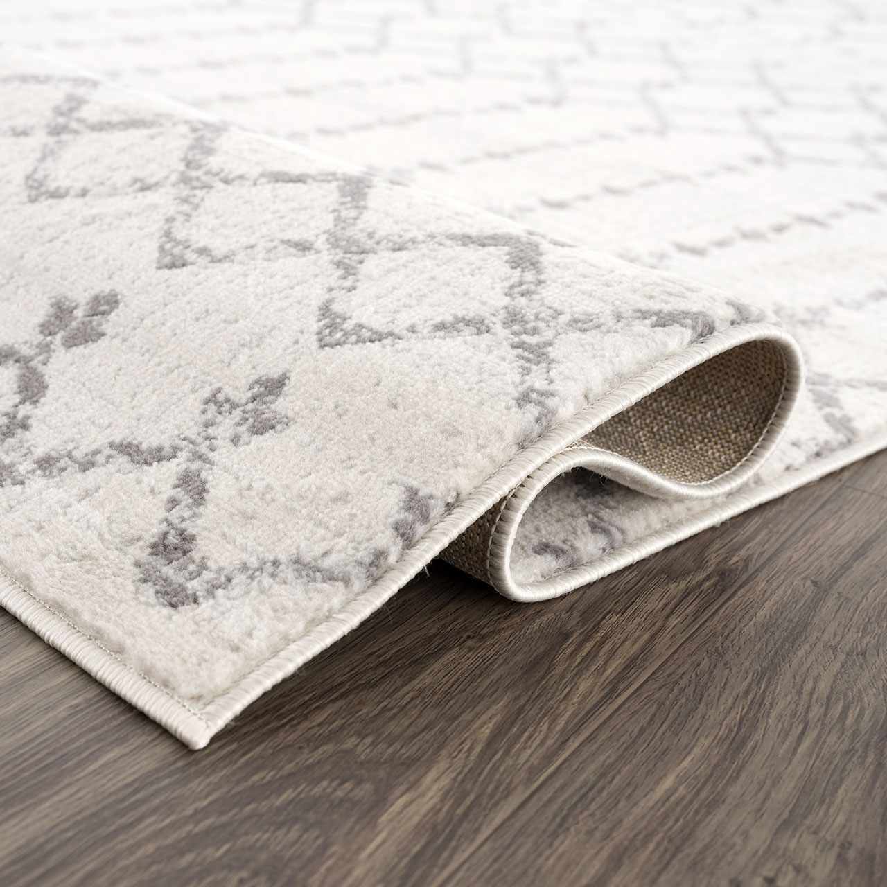 Close-up of the Tigri Aztec 2310 Ivory Rug. Soft pile rug with gray Aztec pattern on an ivory background. Fold