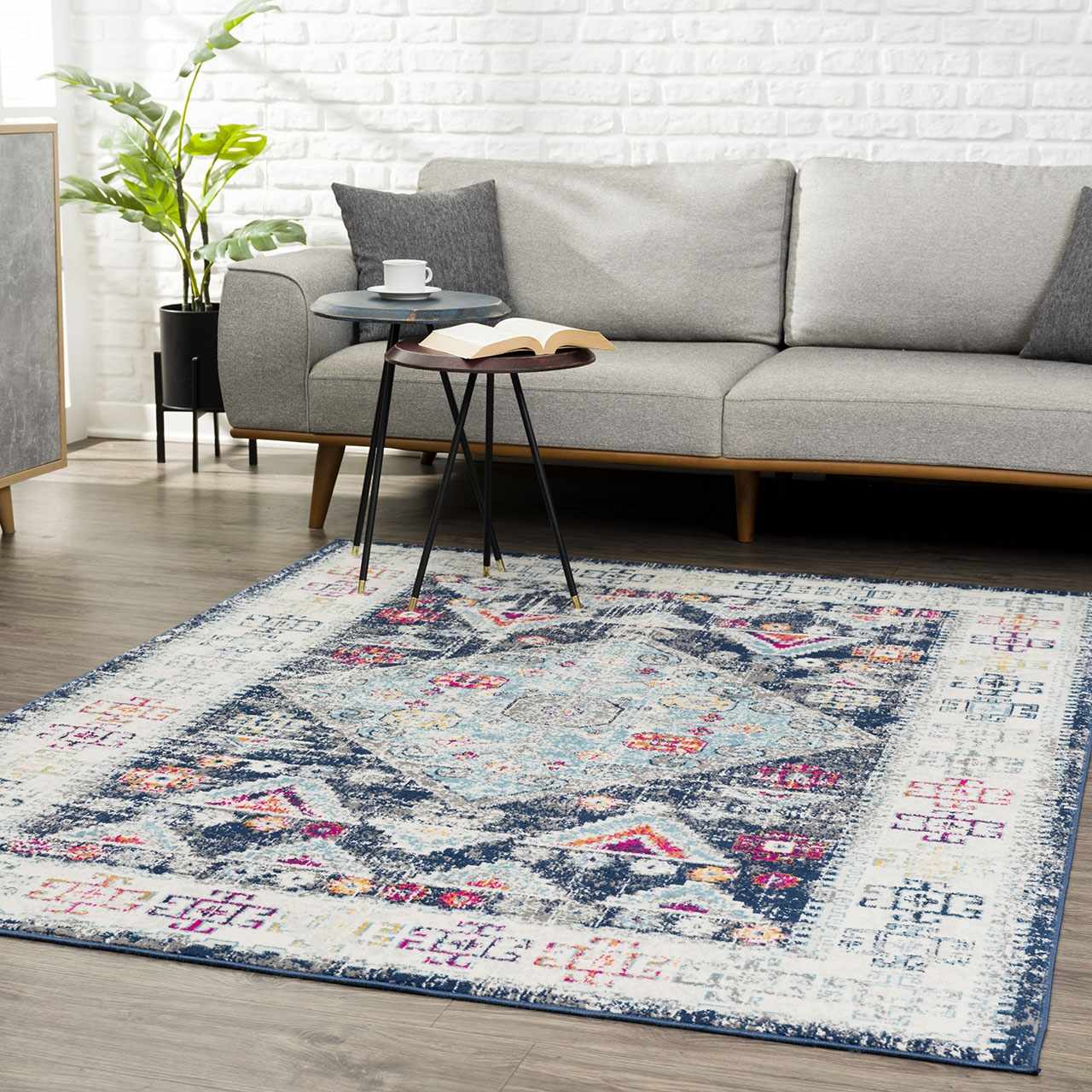 Living room scene with gray sofa and Tigriv Navy 2313 area rug. The rug features bohemian-style navy, pink, and orange patterns. Roomscene-Rectangle