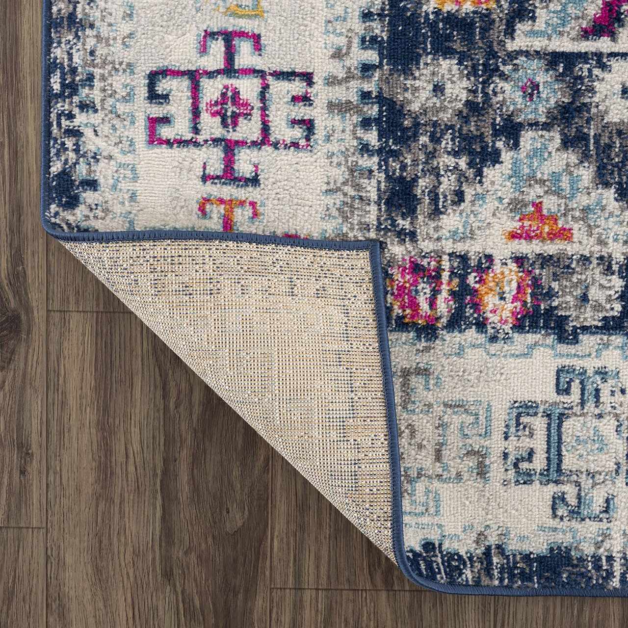 Close-up of Tigriv Navy 2313 Area Rug showing bohemian pattern, navy, pink, orange, and gray colors on wood floor. Fold
