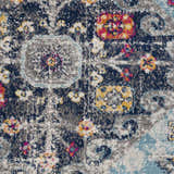 Close-up of Tigris Turquoise 2314 rug. Features ivory, light blue, mustard, navy, orange, and pink in a bohemian pattern. Texture