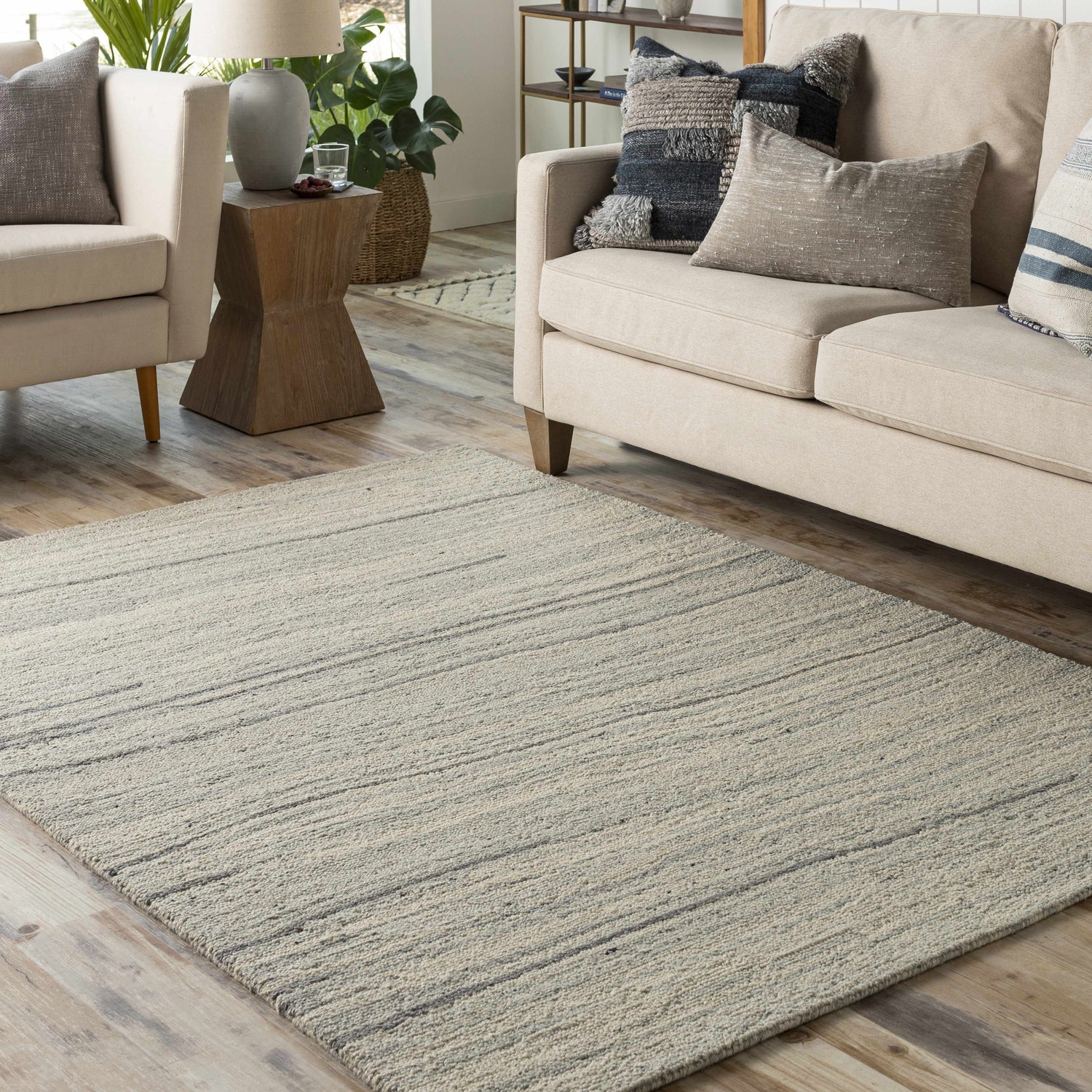Living room scene with a light beige sofa and the light gray Tinubuan Area Rug. Roomscene-Rectangle