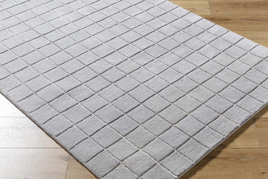 Close-up of the hand-tufted Toshi Sterling Gray Area Rug, a contemporary wool rug with a geometric square pattern. Corner