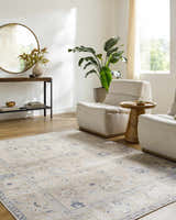 Living room scene with beige Toddy Area Rug, neutral armchairs, wood floors, and console table with round mirror. Roomscene-Rectangle
