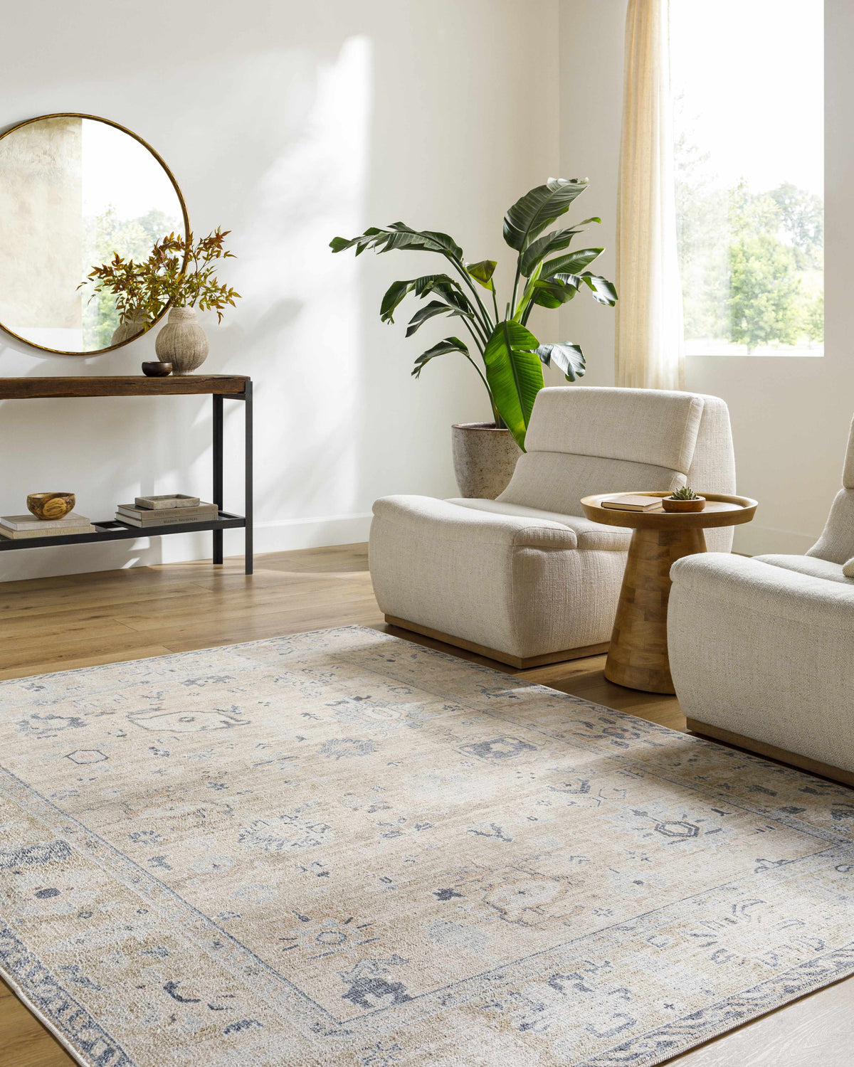 Living room scene with beige Toddy Area Rug, neutral armchairs, wood floors, and console table with round mirror. Roomscene-Rectangle