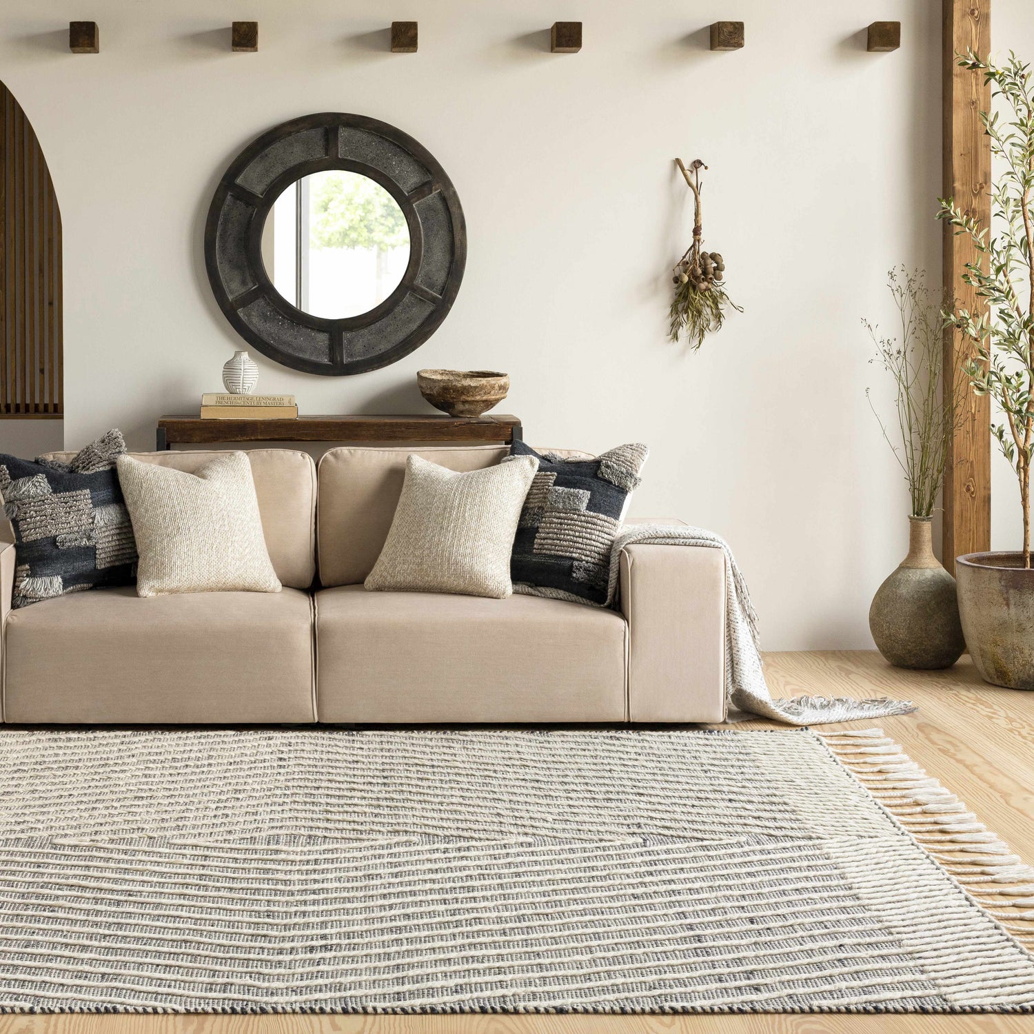 Living room scene with a beige sofa and the Tamayong Tasseled Jute&Wool Rug in black and cream, creating a bohemian farmhouse vibe. Roomscene-Rectangle