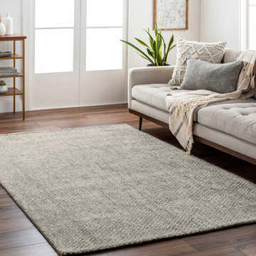 Living room scene with a light beige sofa and the charcoal Toboy Area Rug on dark wood floors. Roomscene-Rectangle