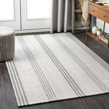 Scandinavian-style room with a Treichlers Area Rug in gray stripes, wood console table, and woven ottoman. Roomscene-Rectangle