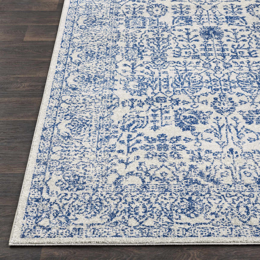 Close-up of the Truxton Area Rug. Light beige rug with a distressed navy, vintage-inspired pattern. Front