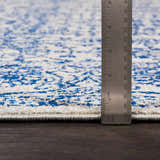 Close-up of the Truxton Area Rug showing its light beige and navy bohemian pattern, texture, and rug thickness. Pile
