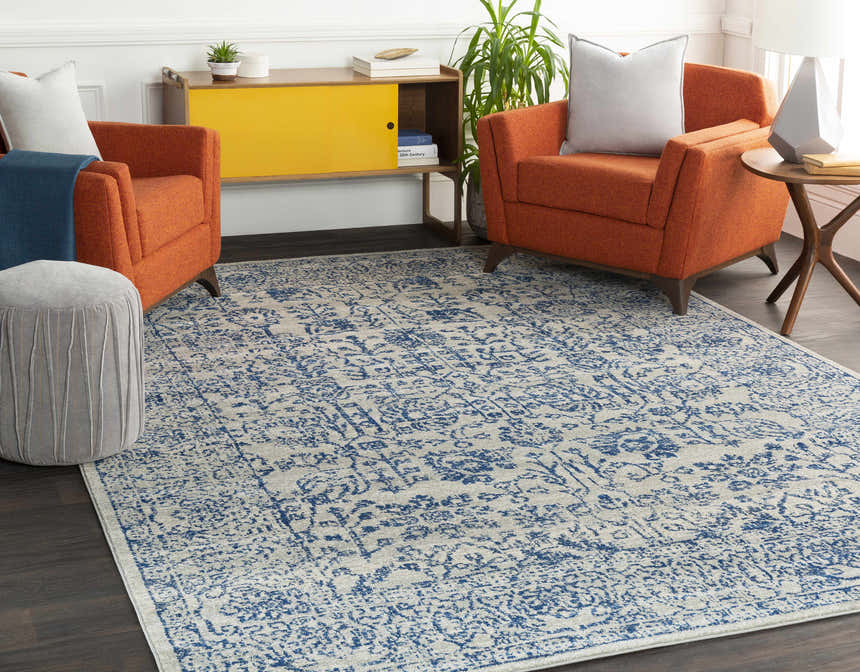 Living room scene with orange armchairs and a light beige and navy Truxton Area Rug. Roomscene-Rectangle