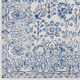 Close-up of the Truxton Area Rug. Light beige rug with a distressed navy blue traditional pattern. Swatch