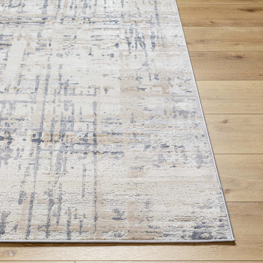 Close-up of the Tut Textured Luxe Rug in charcoal, ivory, beige, and gray on wood flooring. Contemporary style. Front