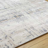 Close-up of the textured Tut Luxe Rug in charcoal, ivory, light beige, and gray on a wood floor. Texture