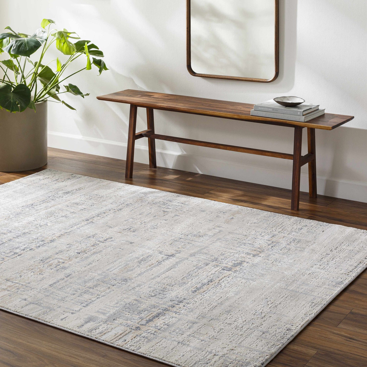 Entryway with a Tut Textured Luxe Rug, wood bench, mirror, and potted plant. Roomscene-Rectangle