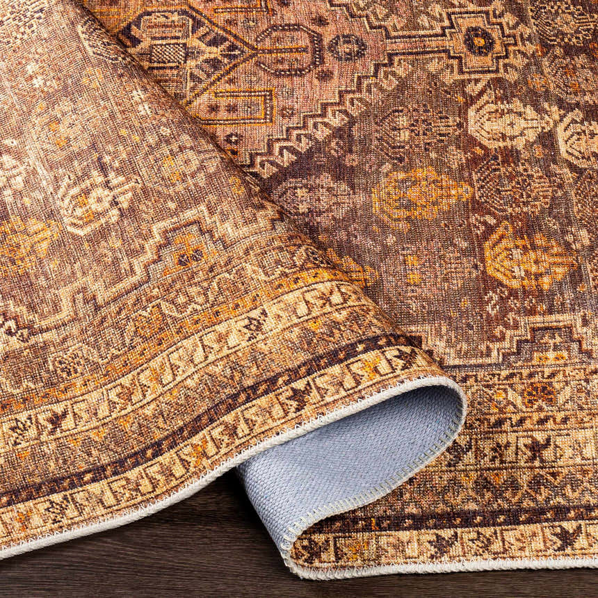 Close-up of the Tungao Washable Area Rug. Bohemian style rug with brown, burnt orange, and beige oriental pattern. Fold