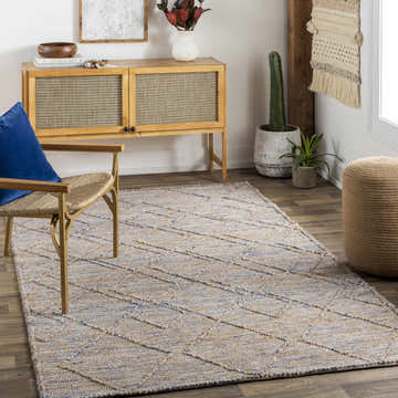 Bohemian living room with jute Buse Hand Woven Beige & Blue Area Rug, wood cabinet, woven chair, and plants. Roomscene-Rectangle