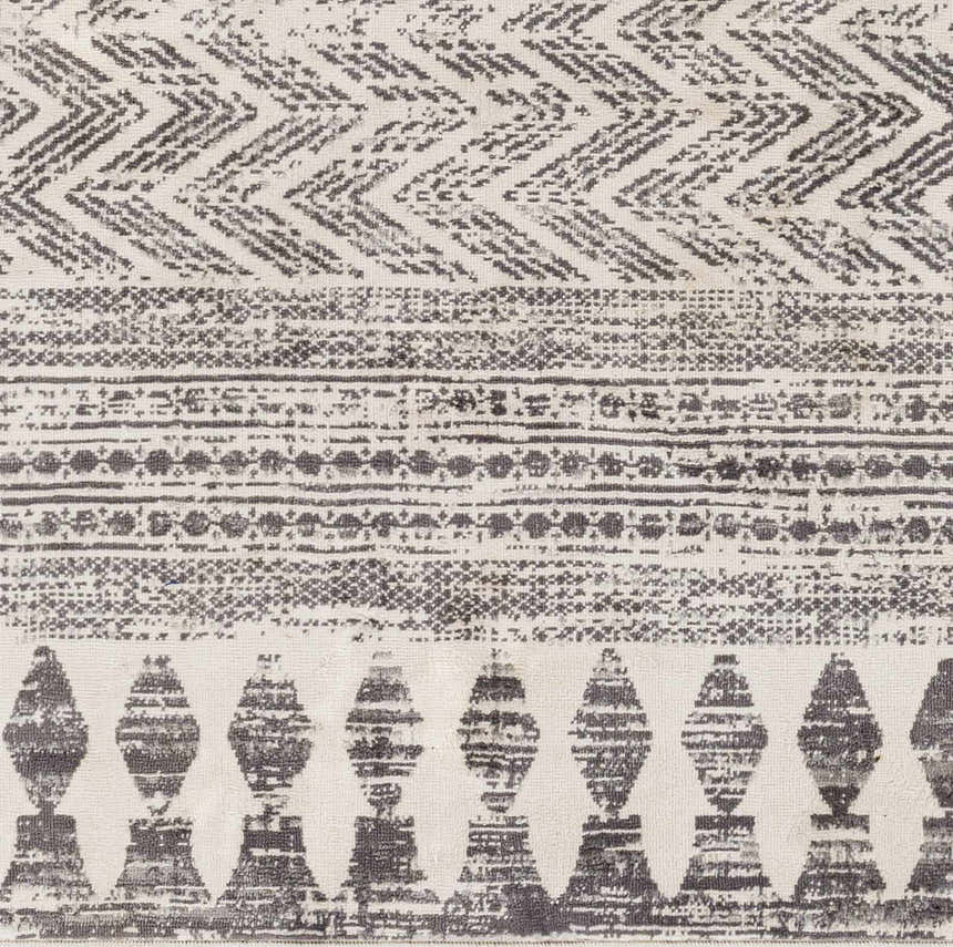 Close-up of the Tuy Area Rug featuring a gray bohemian-inspired geometric pattern and textured weave. Swatch