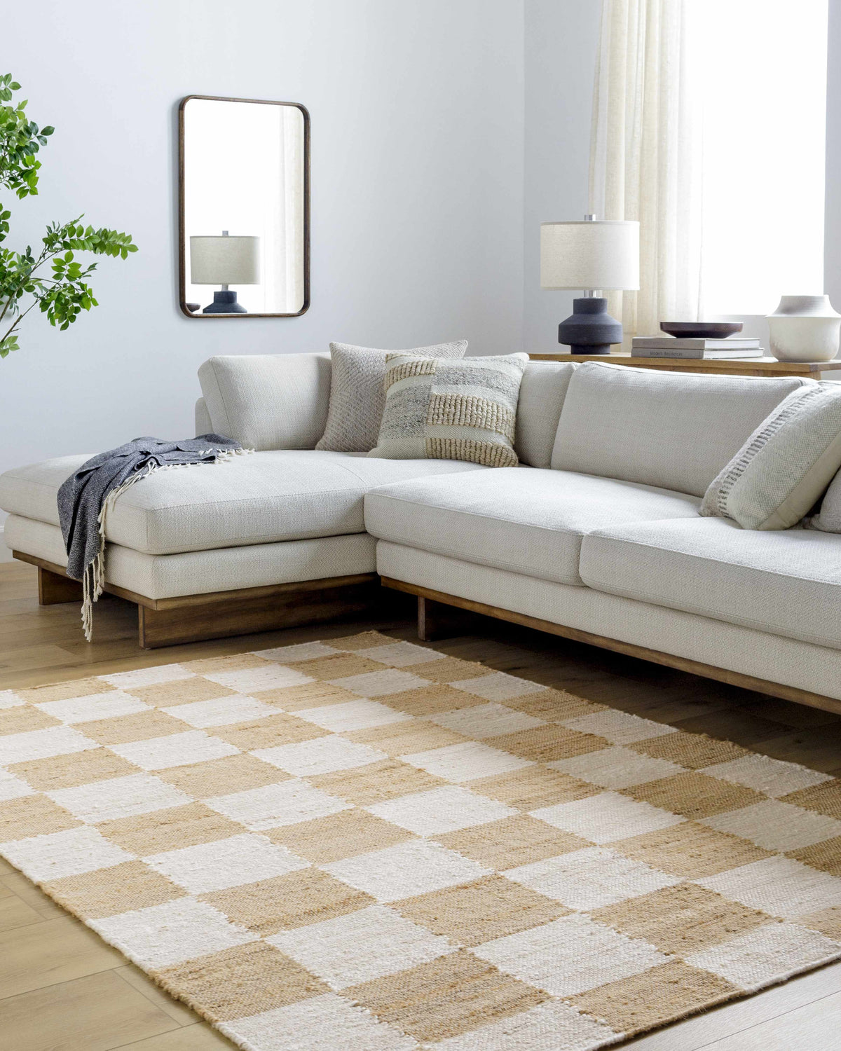 Living room with a light beige sectional sofa and Tyhir Checkered Jute Rug in light brown and white. Roomscene-Rectangle