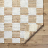 Close-up of the Tyhir Checkered Jute Rug. Hand-woven light brown and white checkered pattern with jute texture. Fold