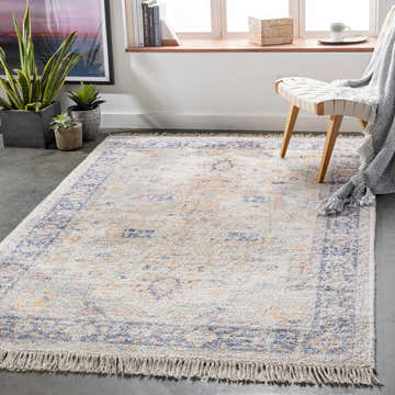 Living room scene with a Tyro Carpet in aqua, beige, and orange. Bohemian rug styled with a chair, plants, and a window. Roomscene-Rectangle