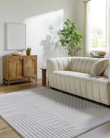 Living room with a cream sofa and a sage and silver gray Tohfa Area Rug with a geometric design. Roomscene-Rectangle