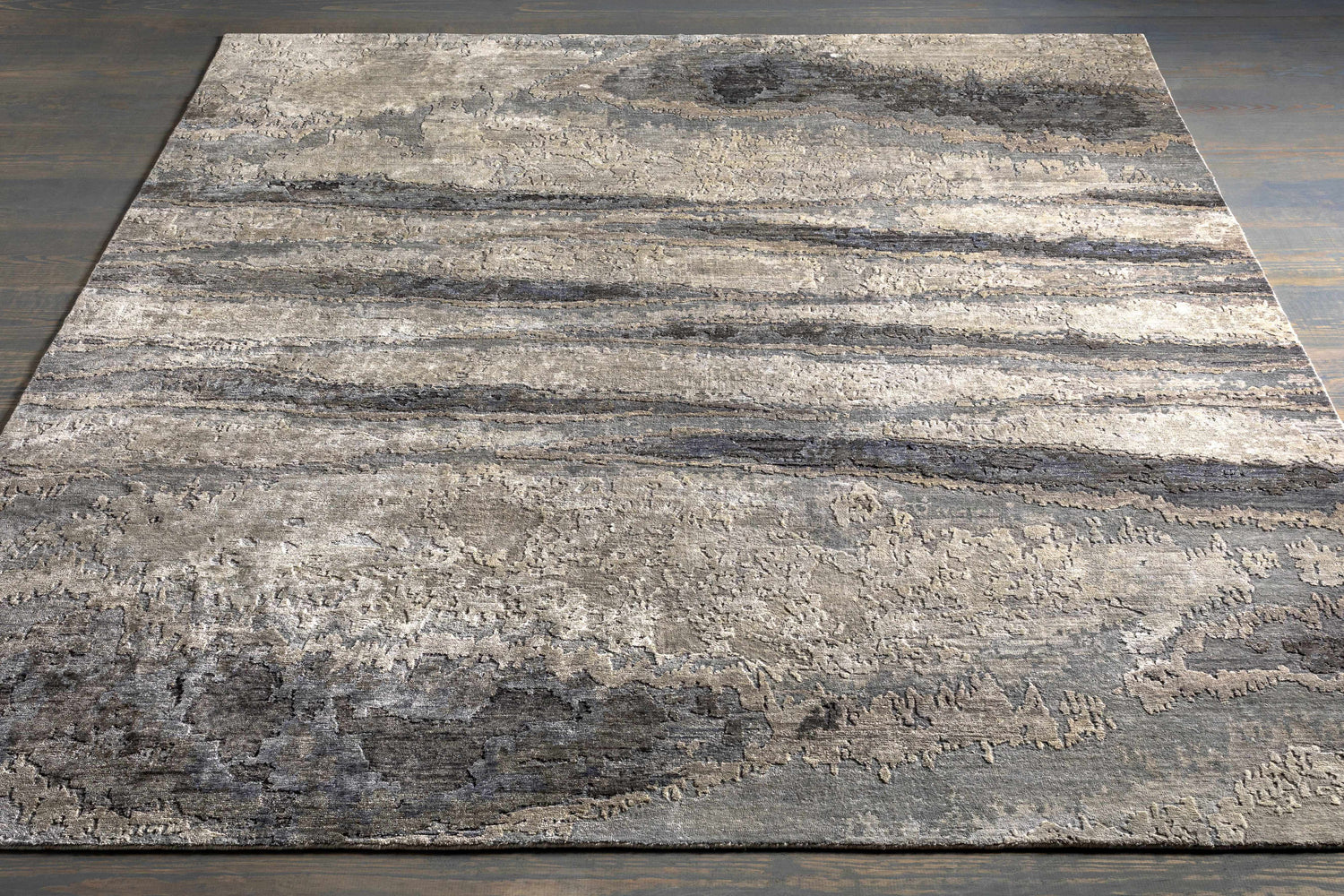 Close-up of the Vincentown Area Rug. Contemporary design in charcoal, brown, denim, and gray viscose with a hand-knotted texture. Styleshot