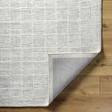 Close-up of the hand-tufted Urian Area Rug. Light silver and silver gray wool rug with a subtle contemporary pattern. Fold