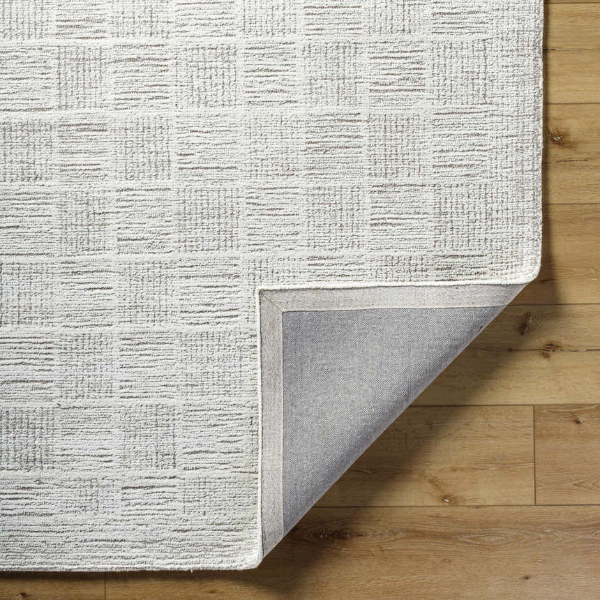 Close-up of the hand-tufted Urian Area Rug. Light silver and silver gray wool rug with a subtle contemporary pattern. Fold