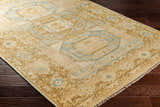 Close-up of the hand-knotted Villareal Area Rug, a traditional design in cream, beige, and ice blue on dark wood floors. Corner