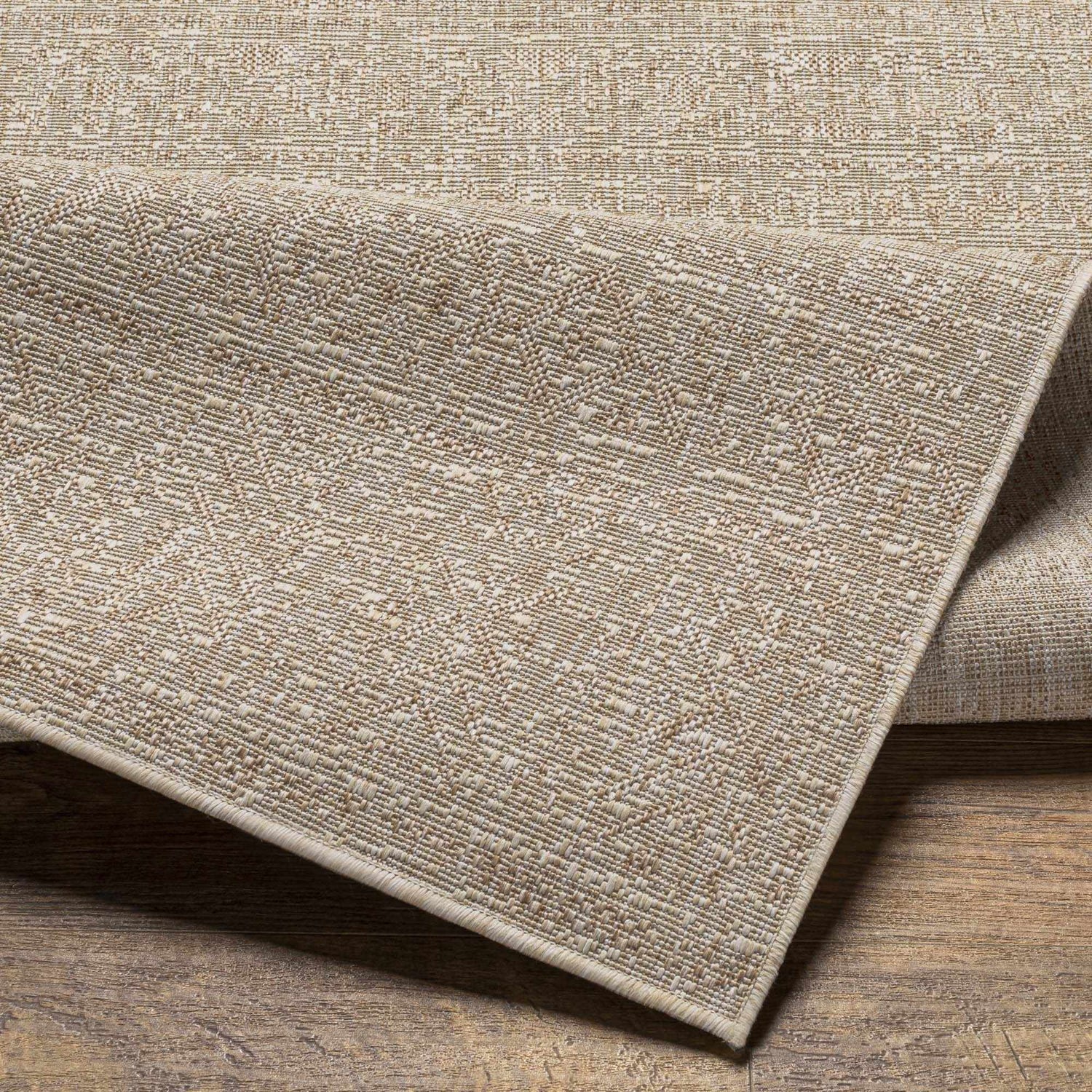 Close-up of the Vanderhoof Indoor & Outdoor Rug showing its mocha and light peach woven texture and neutral color palette. Fold