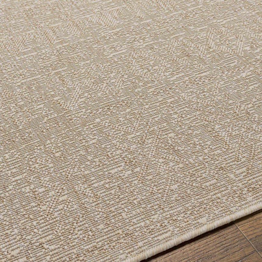 Close-up of the Vanderhoof Indoor & Outdoor Rug. Neutral light peach and mocha tones with a subtle geometric pattern. Texture
