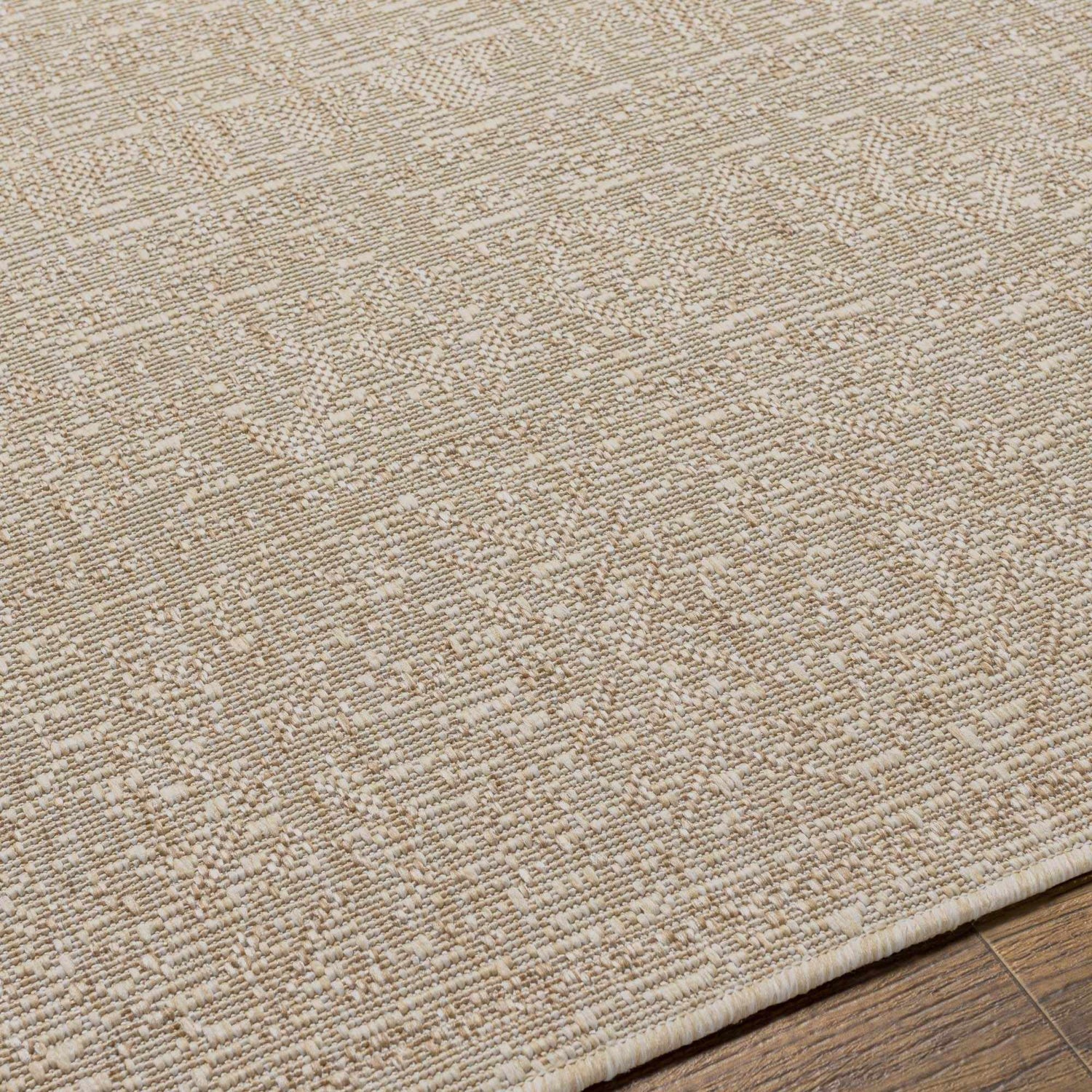 Close-up of the Vanderhoof Indoor & Outdoor Rug. Neutral light peach and mocha tones with a subtle geometric pattern. Texture