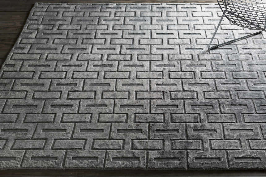 Close-up of the hand-knotted Voca Area Carpet. Contemporary style with a textured gray geometric pattern. Styleshot