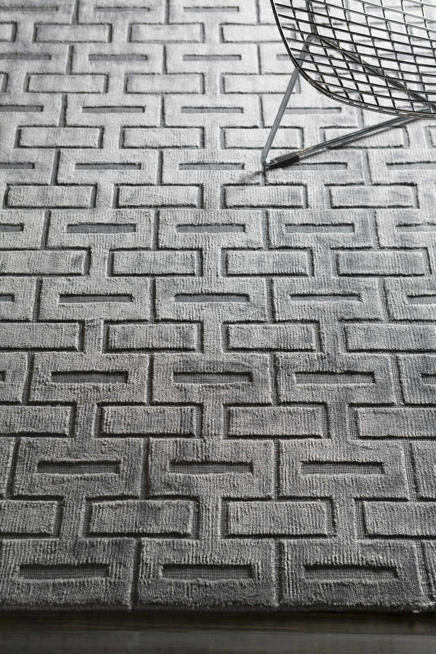 Close-up of the hand woven Voca Area Carpet. Contemporary gray rug with a geometric brick pattern and soft texture. Styleshot