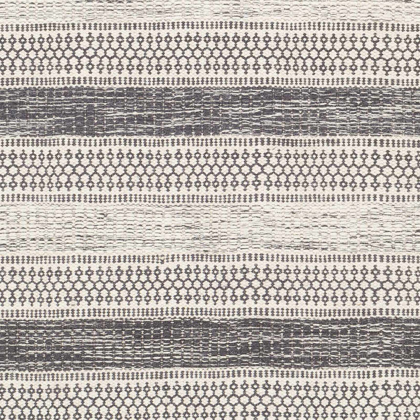 Close-up of the Vernonia Area Rug. Hand-woven wool rug with black stripes and ivory geometric patterns. Swatch