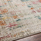 Close-up of the Eversley Area Rug, a cream rug with dark blue, pink, mustard, and gray abstract pattern. Texture