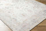 Close up of the Valko Area Rug. Machine woven polyester rug with dusty pink, gray, and light brown traditional pattern. Corner